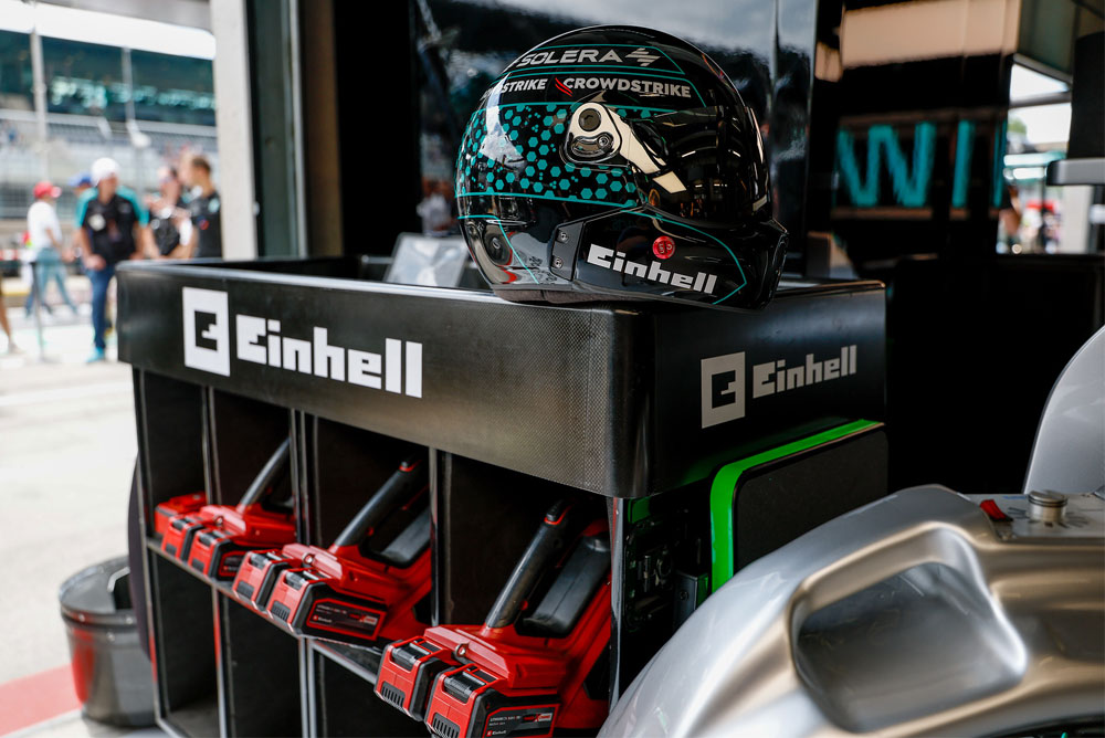 Utensili a batteria Einhell in un carrello, con un casco da corsa in cima.
