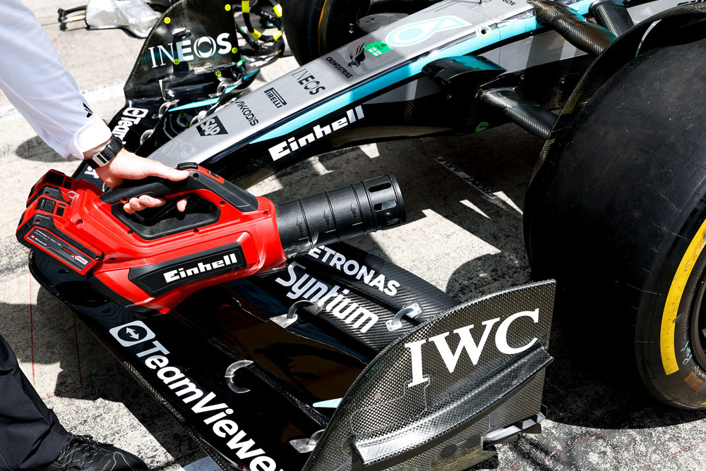 Soffiatore di foglie Einhell puntato contro l'ala anteriore di un'auto di Formula 1.