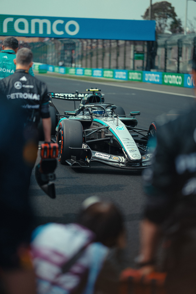 Auto F1 Mercedes ai box circondata dal team