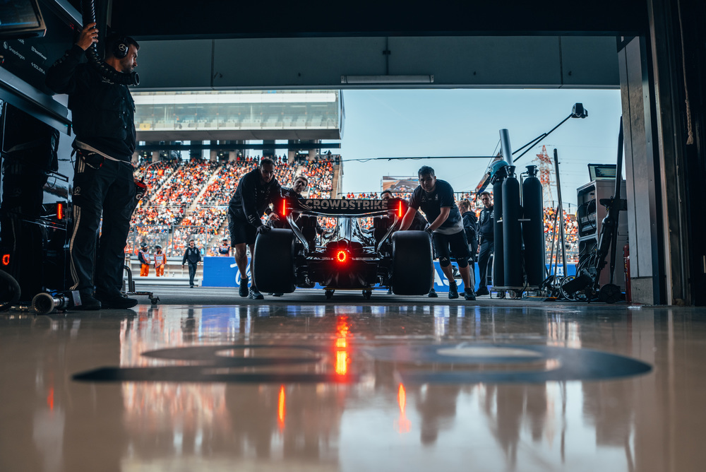 Auto F1 Mercedes nel garage con attrezzature e luci