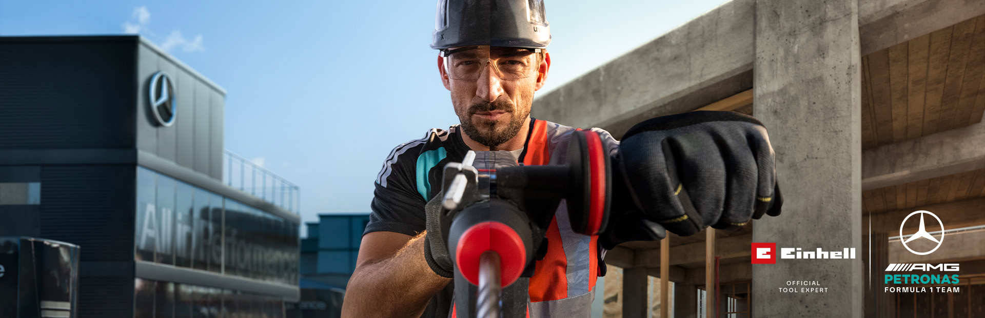 Un meccanico in tenuta protettiva che esegue lavori di foratura con un utensile elettrico in un cantiere.