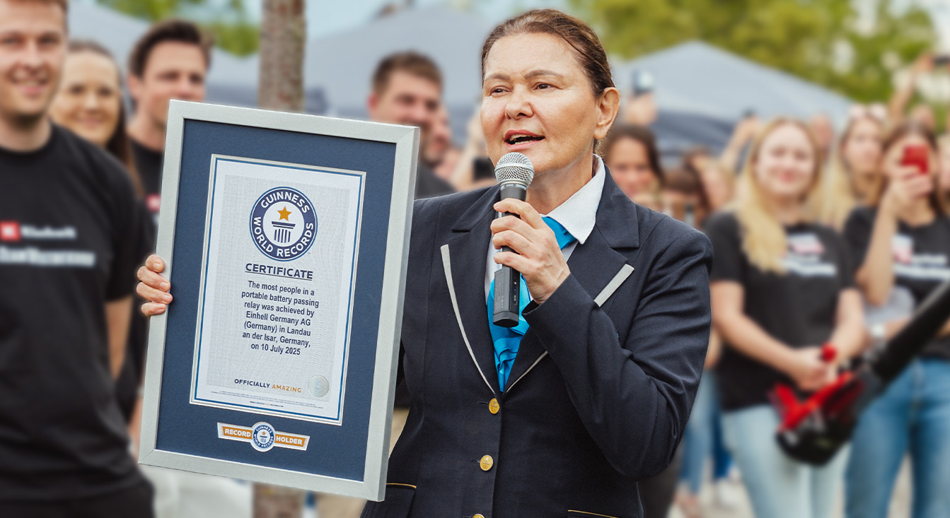 La batteria Einhell SEALED Power X-Change da 4,0 Ah giace sull'asfalto, con il logo “Record Holder” del Guinness World Records sulla destra.